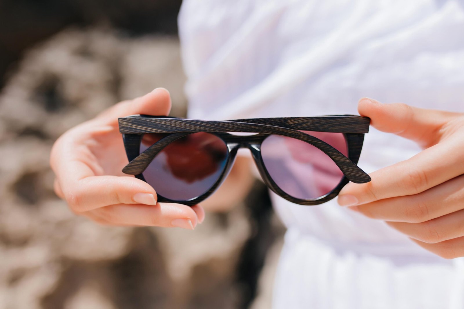 woman-white-attire-holding-dark-glasses-photo-female-hands-with-sunglasses